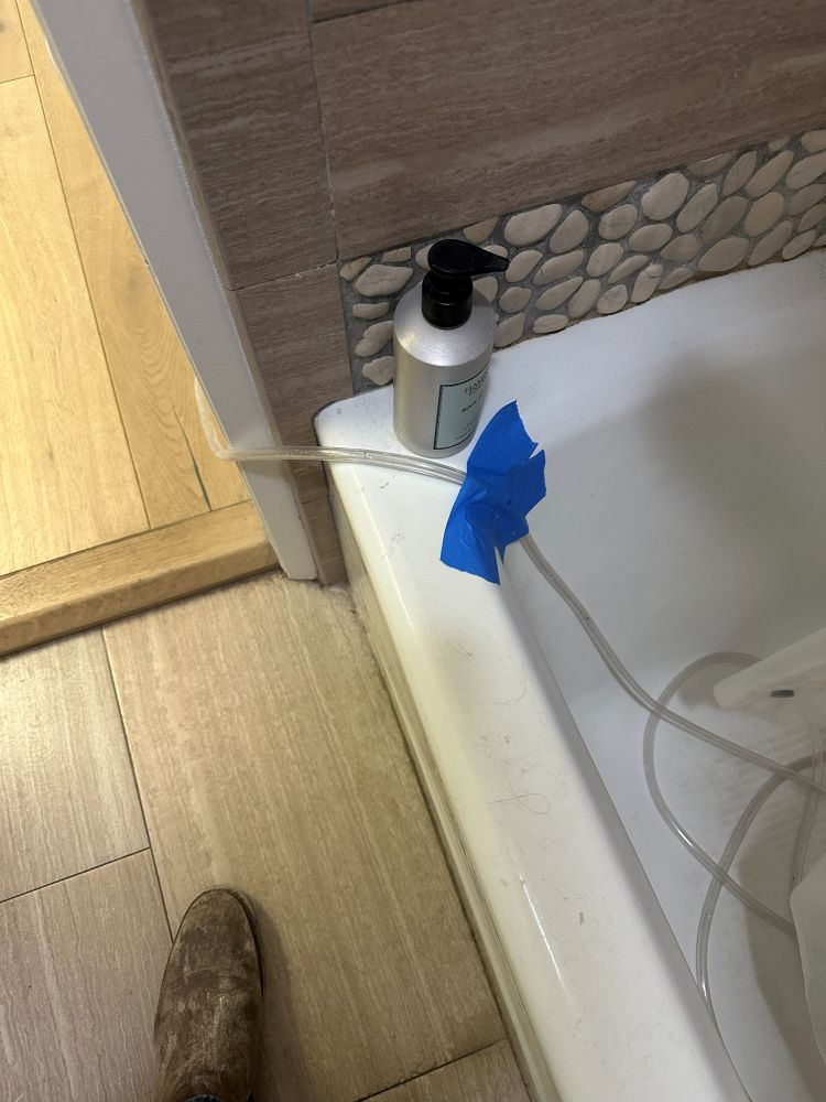 Dehumidifier drain line running into a bathtub