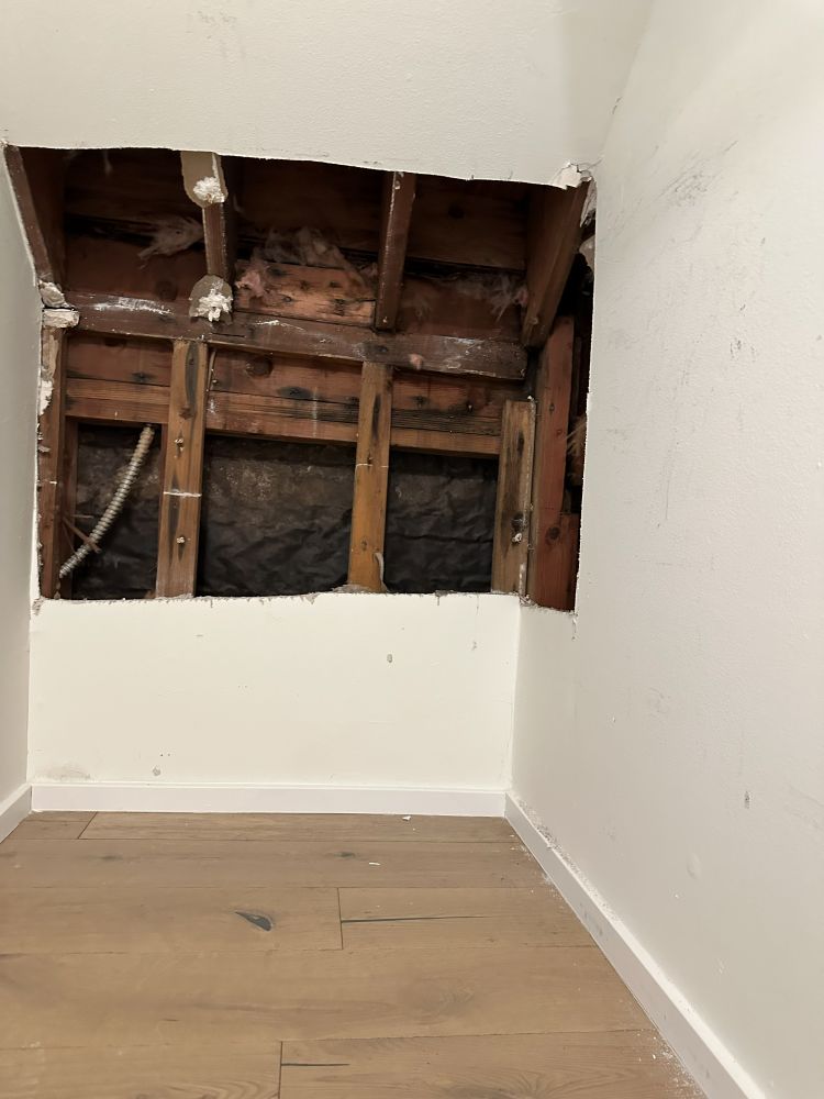 Water-damaged drywall removed to expose wall framing